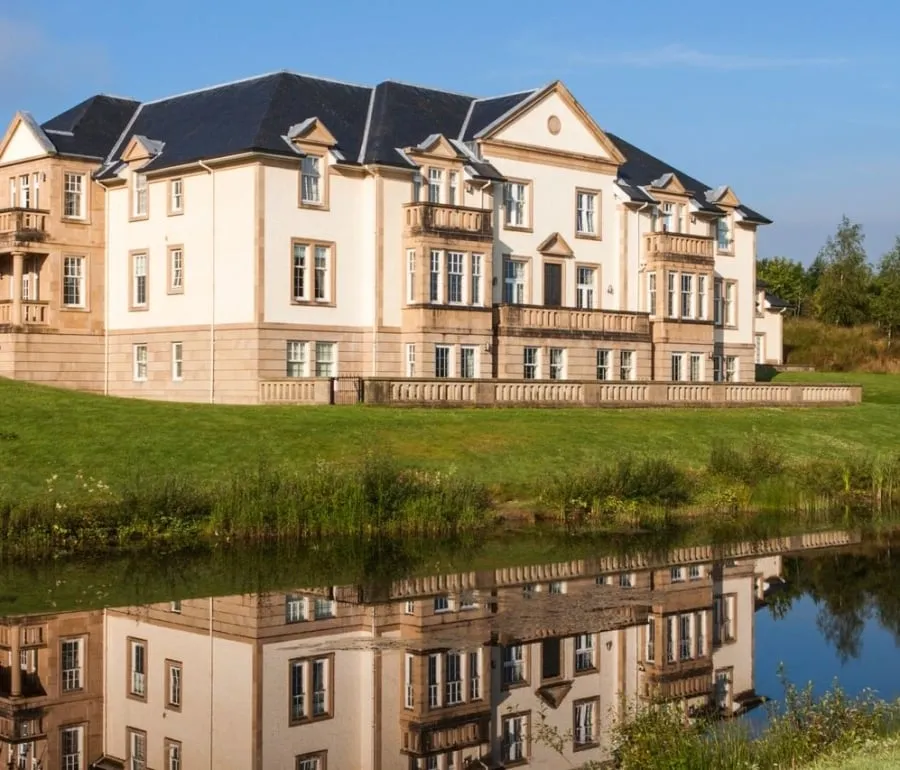 Exterior of Loch Lomond Apartments reflected in a nearby pond.