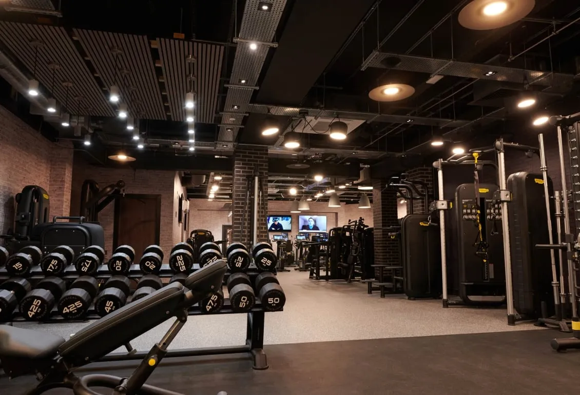 Cameron house indoor gym with weights on a rack and other equipment