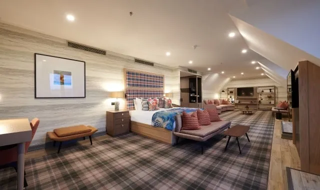 a large open bedroom with a bed and sitting area